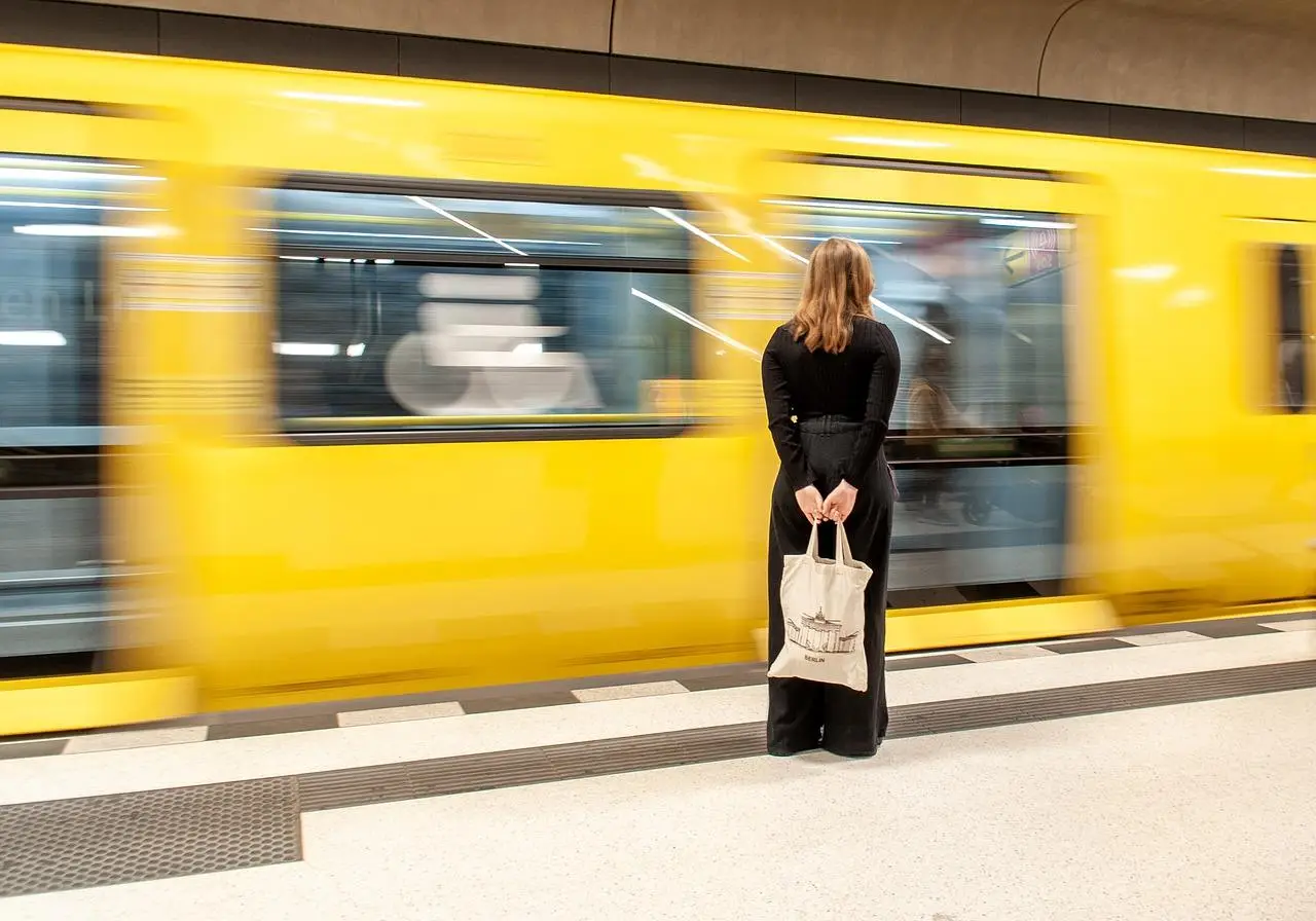 Vrouw stond naast een gele elektrische trein in Breda