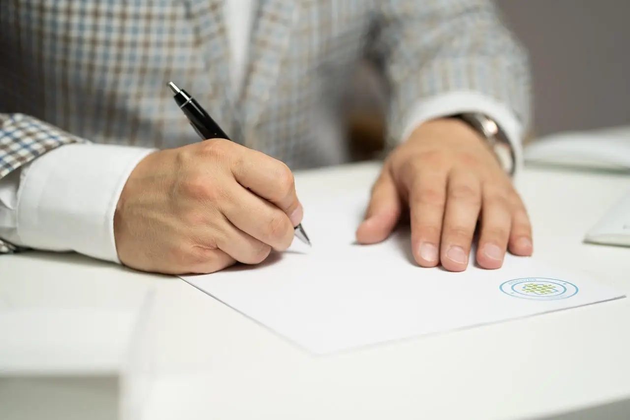 Een man in een pak schrijft op papier