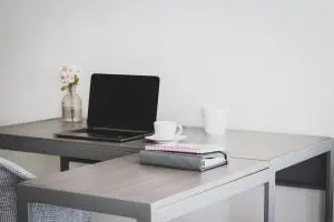 Bedrijven in Breda Een L-vormige tafel met een laptop erop.